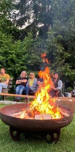 eine Gruppe von Menschen, die um eine Feuerstelle sitzen